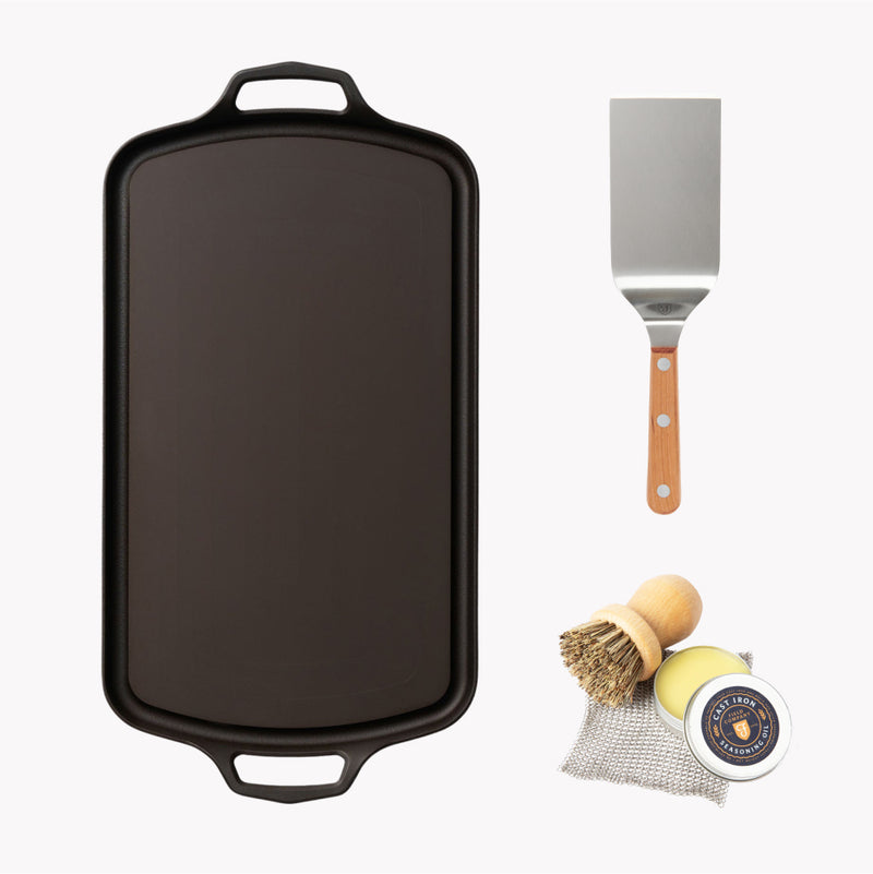 Overhead of the Long Griddle Starter Set: Field Long Griddle with griddle turner, pot brush, chain mail, and seasoning oil