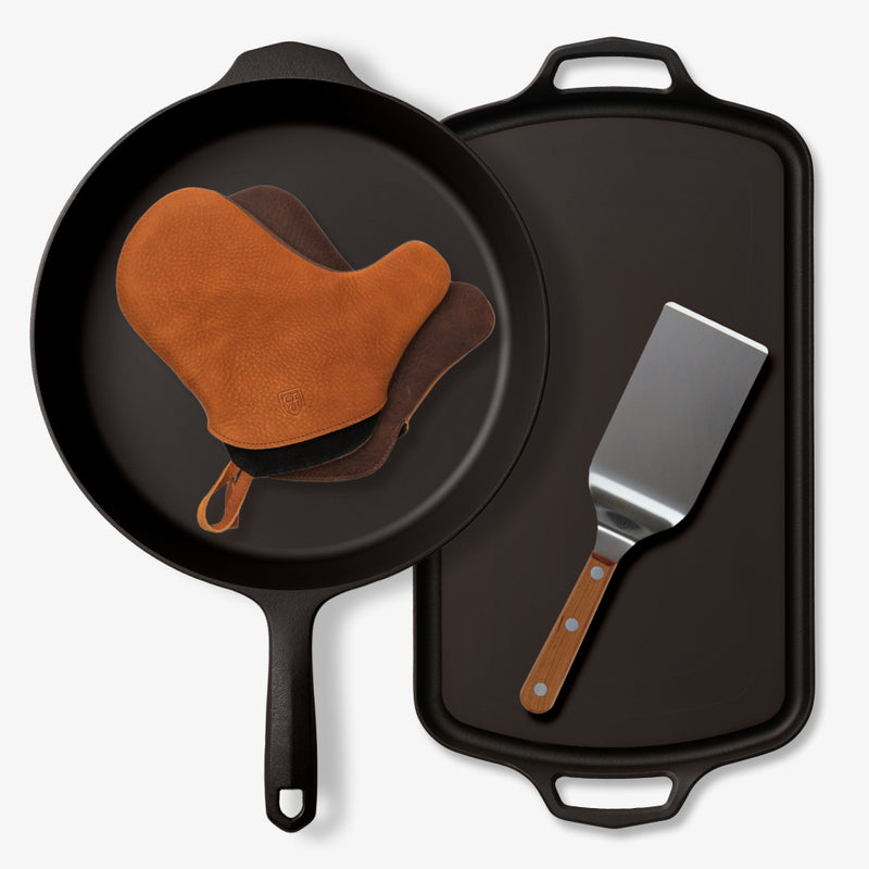 Field Ultimate Cast Iron Grilling Set overhead: skillet with leather oven mitts, Long Griddle, and griddle turner