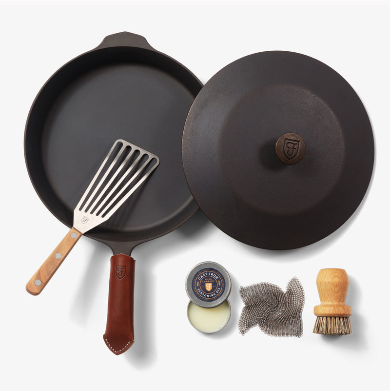 Overhead of the Chef's Starter Set No.10: Field Skillet with lid, slotted turner, leather handle cover, and care tools