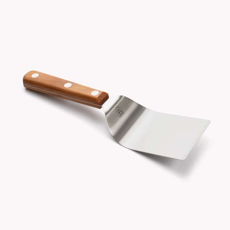 Angled view of the Field Mini Turner with wide stainless blade and cherry wood handle