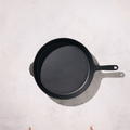 Overhead view of the No.12 Field Cast Iron Skillet on a plaster surface, helper handle opposite the main handle thumbnail