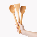 Hand holding the three Field cherry wood spoons and spatulas fanned out thumbnail