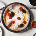 Dutch baby topped with berries and powdered sugar in the No.6 Field Cast Iron Skillet thumbnail