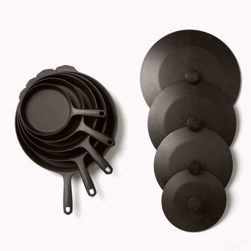 Overhead of the Field 9-Piece Set: nested skillets and griddle beside four graduated cast iron lids