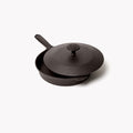 Angled view of a Field Skillet with cast iron lid resting slightly offset above the rim thumbnail