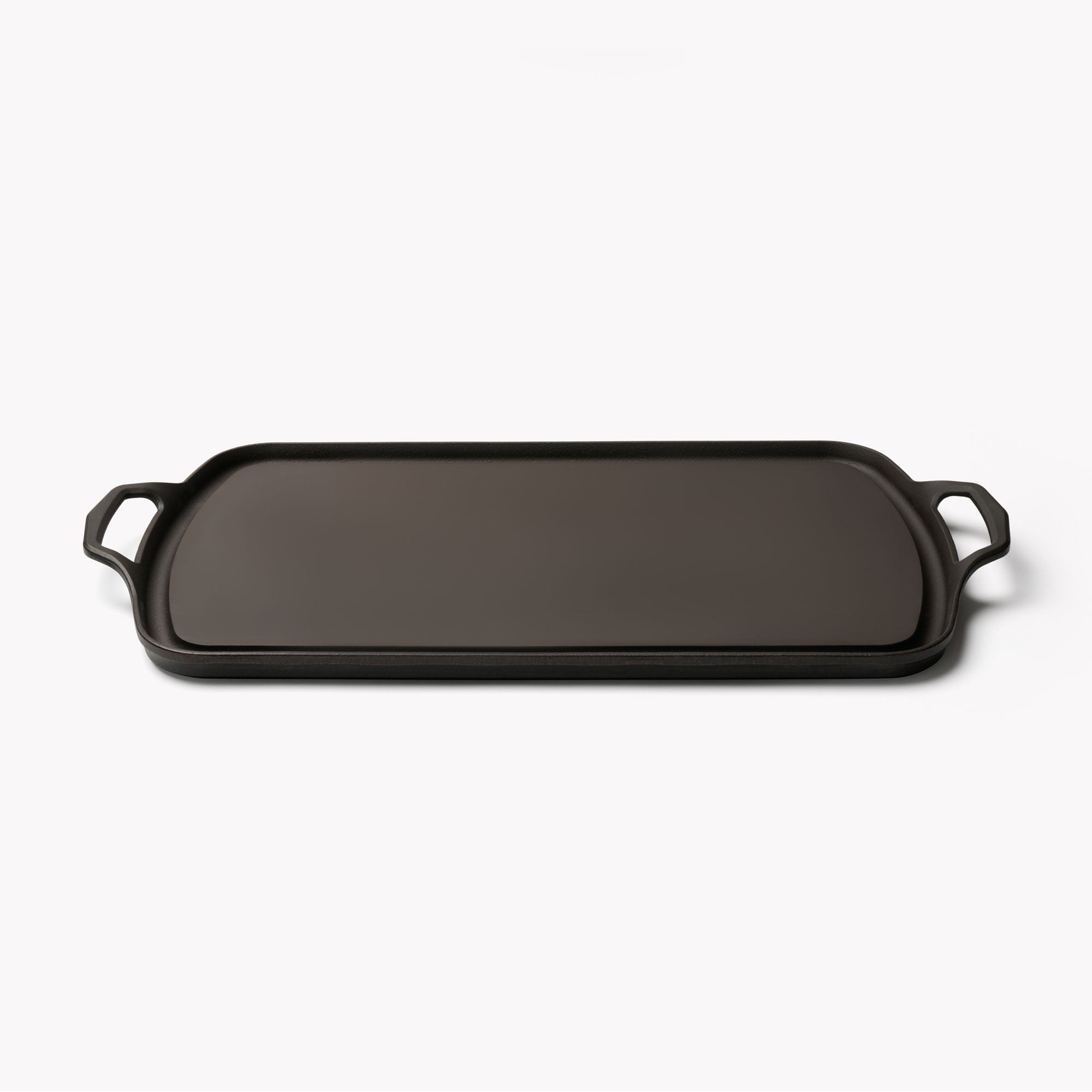 Side profile of the Field Long Cast Iron Griddle, showing its low rim and loop handles