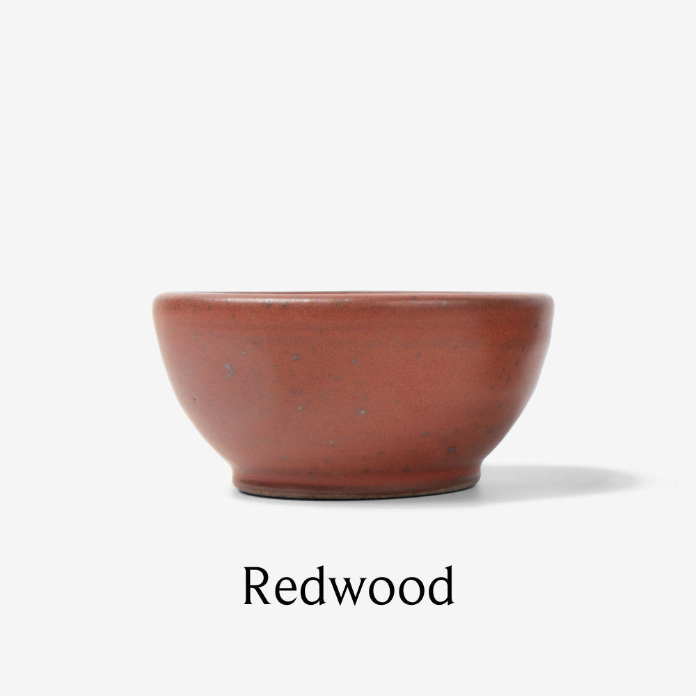Tiny Field ceramic bowl in the Redwood glaze, side view on white background