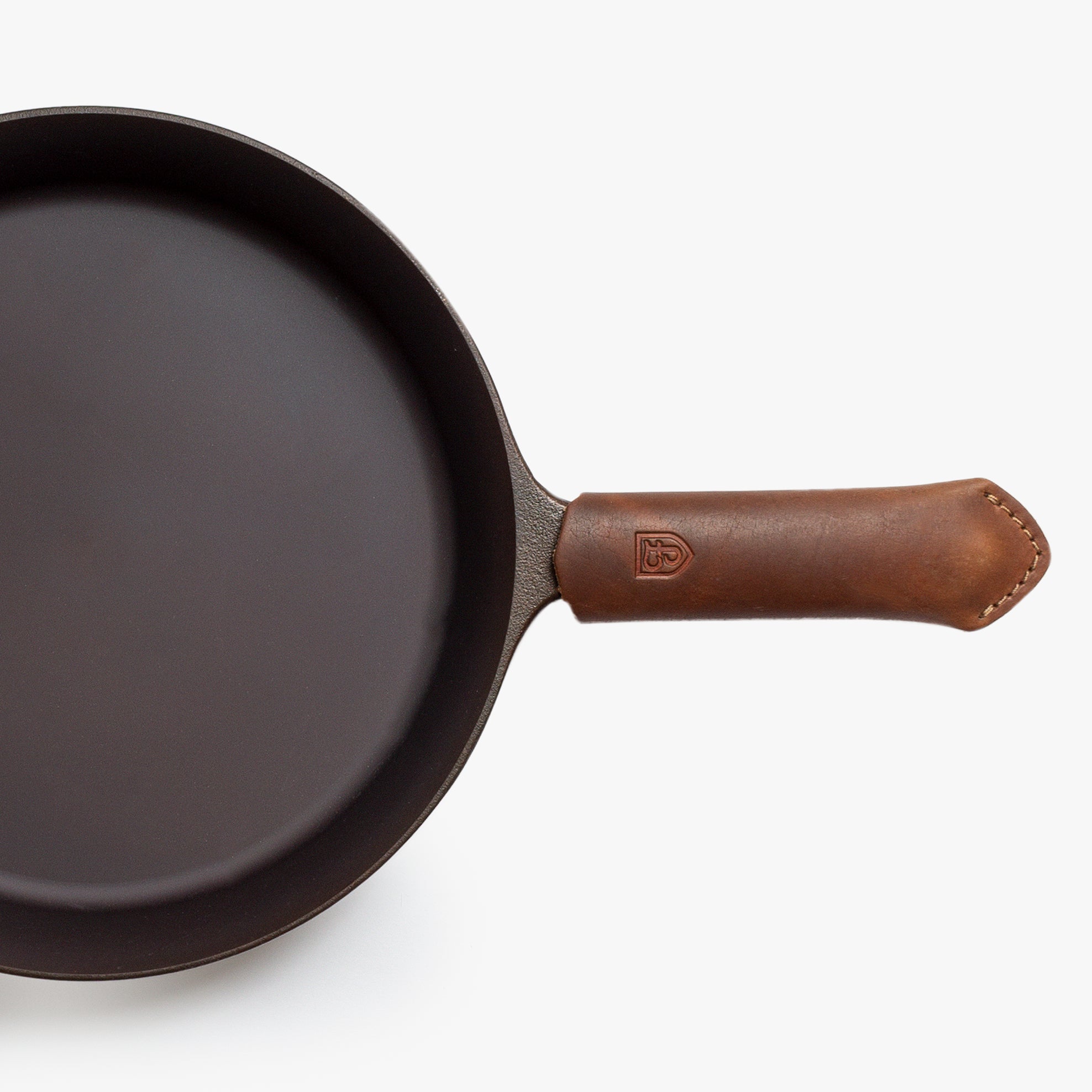 Overhead close-up of the Field Skillet handle wearing a brown leather handle cover
