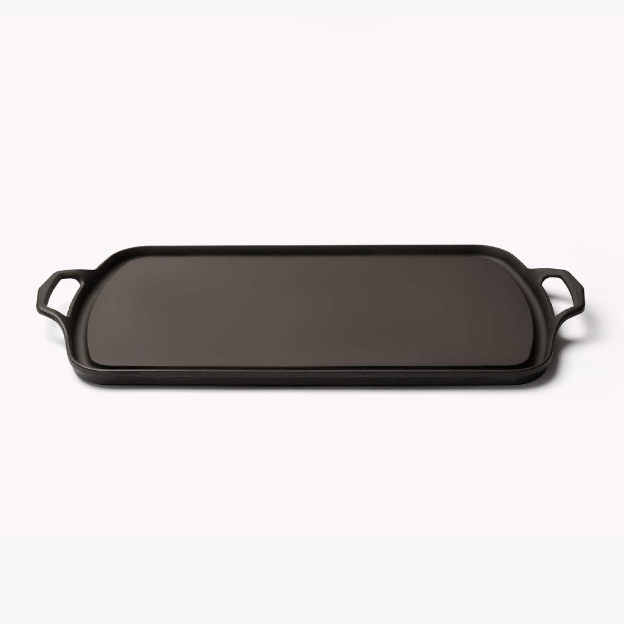 Angled view of the Field Long Cast Iron Griddle, low rim and loop handles