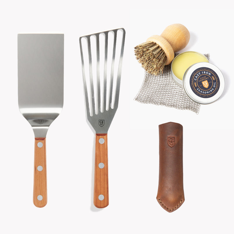 Field Cast Iron Tools Set laid out: two turners, scrub brush, chain mail, seasoning oil, and leather handle cover