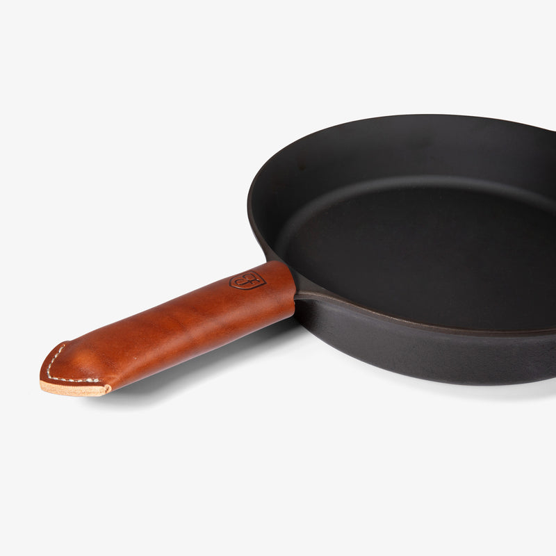 Tan Field Leather Handle Cover with stitched tip fitted on the handle of the Field Skillet