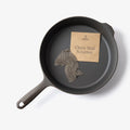 Field Company Chain Mail Scrubber and kraft packet resting inside a cast iron skillet, overhead view thumbnail