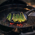 Asparagus spears grilling on the No.9 Field Round Cast Iron Griddle over glowing charcoal in a kettle grill thumbnail