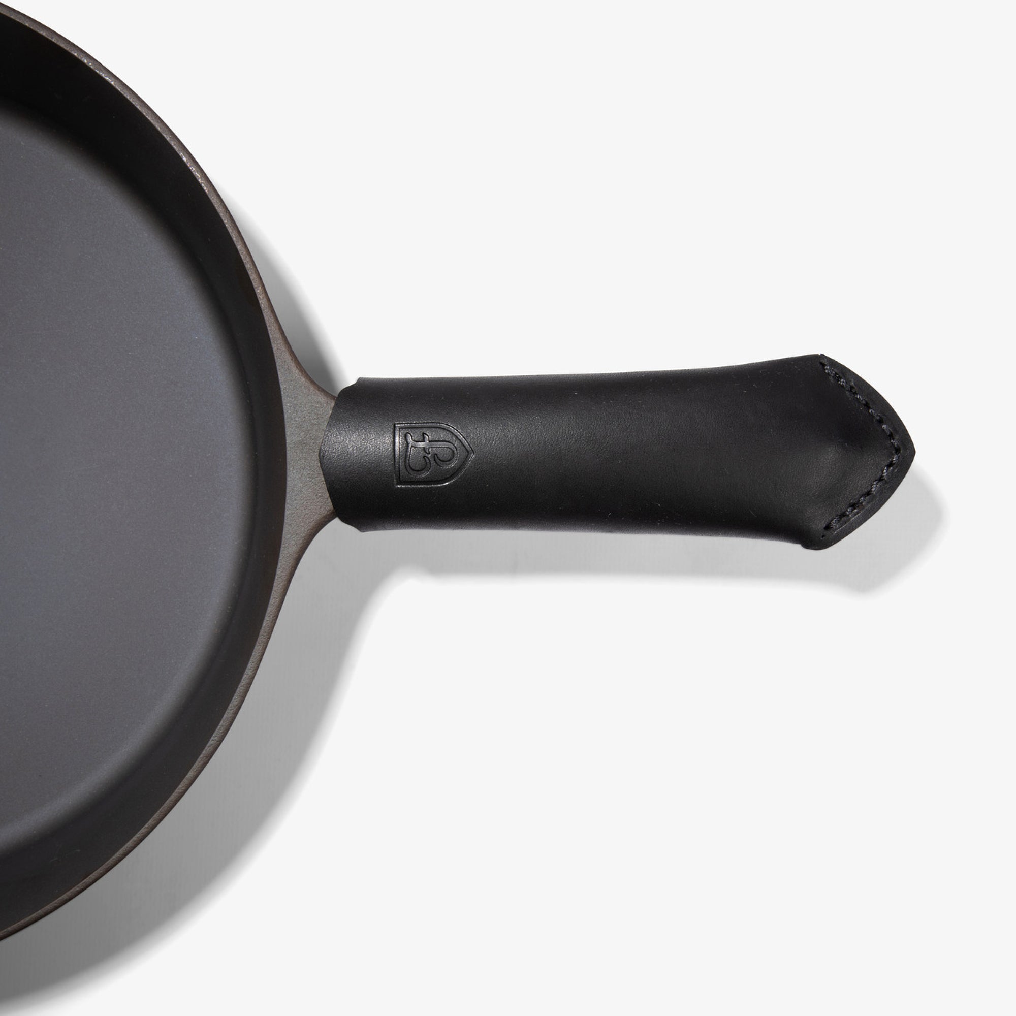 Black Field Leather Handle Cover with stitched tip fitted on the handle of the Field Skillet, seen from above