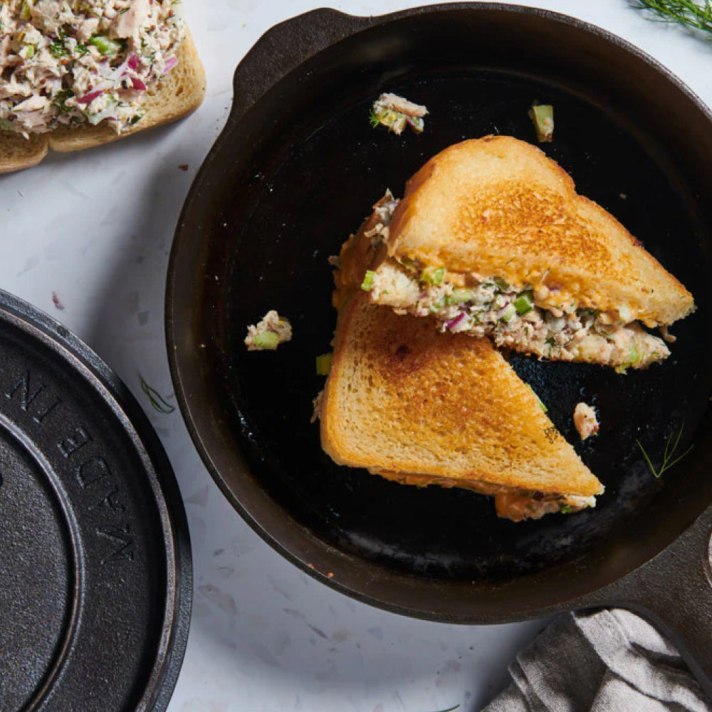 Toasted tuna salad sandwich halves in the No.6 Field Cast Iron Skillet, lid alongside, overhead view