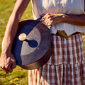 Woman carrying a Field Dutch Oven outdoors, its lid fitted with the polished Bronze Knob thumbnail