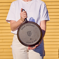 Person holding a No.8 Field Cast Iron Skillet upside down to show the stamped underside, outdoors in sunlight thumbnail