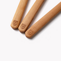 Close-up of three Field Cherry Wood utensil handles marked with the shield logo thumbnail