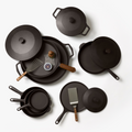 Overhead view of the 12-Piece Field Cast Iron Set: skillets, Dutch ovens, griddles, lids, and wood-handled turners thumbnail
