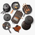 Overhead view of the Cast Iron Collector's Set: Field skillets, Dutch ovens, griddles, lids, wood tools, and oven mitts thumbnail