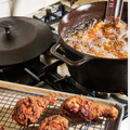 Frying chicken in the No.10 Field Cast Iron Dutch Oven on the stovetop, finished pieces resting on a rack thumbnail