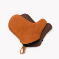 Tan and dark brown Field leather oven mitts overlapping, stamped shield logo and hanging loop visible thumbnail