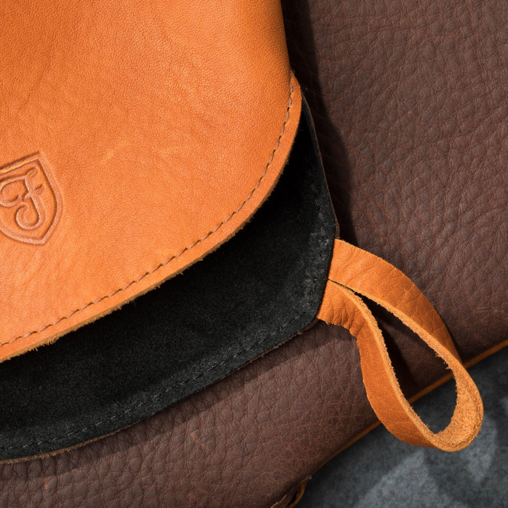 Detail of a Field Leather Oven Mitt showing the stitched hanging loop and tan grain
