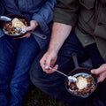 Two people eating fruit crisp with ice cream from No.4 Field Cast Iron Skillets outdoors thumbnail
