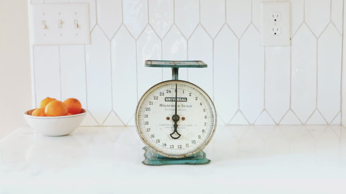 Video of a hand placing a Field Skillet on an antique kitchen scale