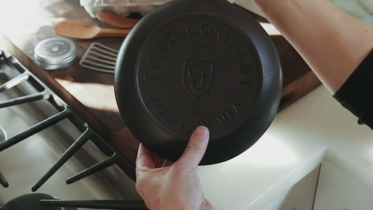 Video of a hand holding the Field Skillet, stamped underside facing the camera