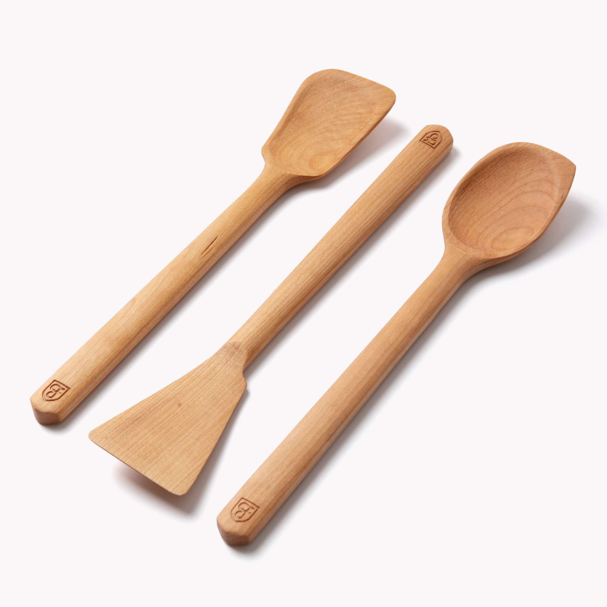Three cherry wood spoons and spatulas with Field Company shield stamps on the handles