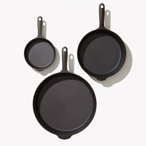 Overhead view of the three Field Skillets in the 3-Piece Cookware Set arranged on white