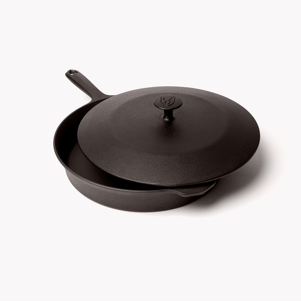 Cast iron lid resting slightly offset on the No.10 Field Skillet, angled view