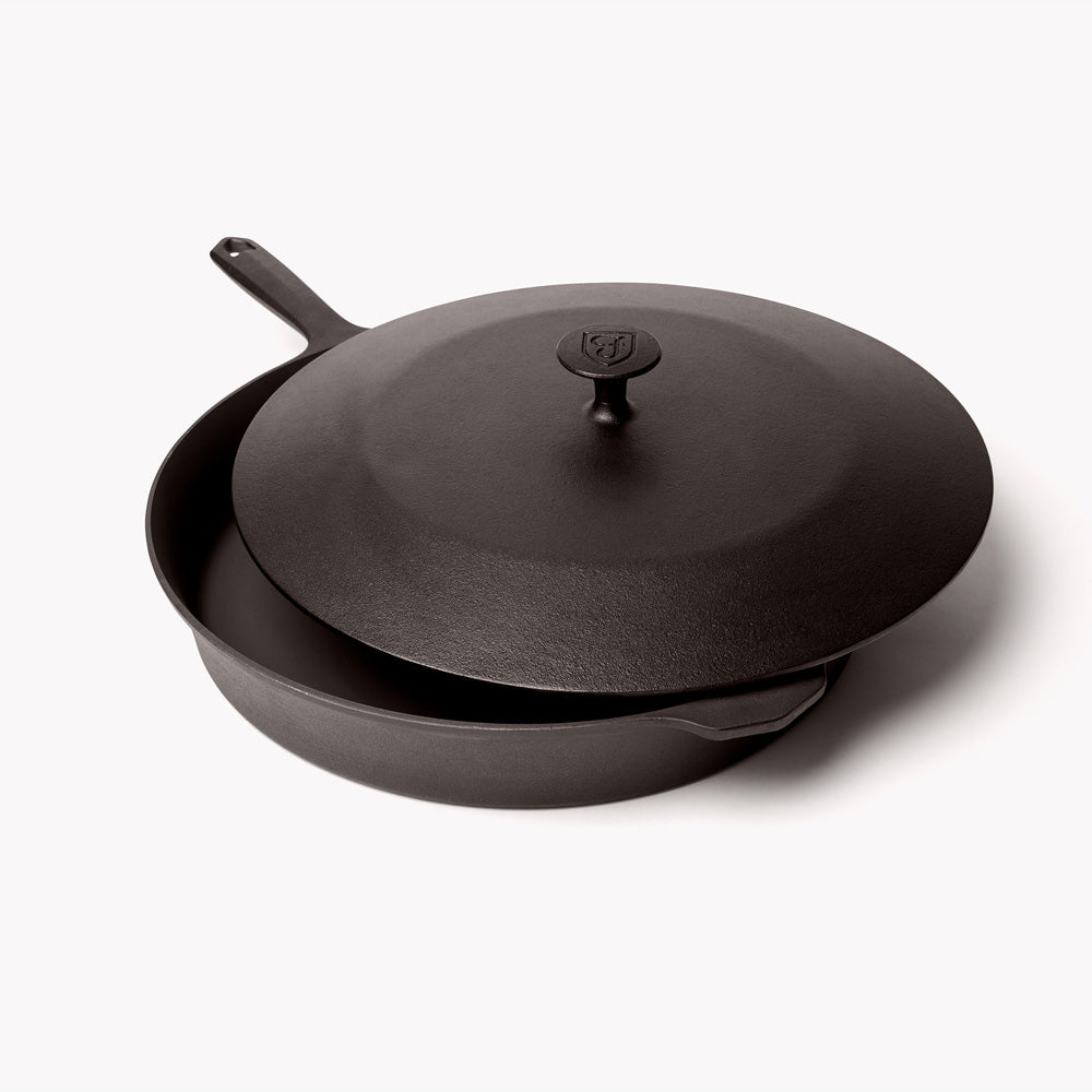 Cast iron lid resting slightly offset on the No.12 Field Skillet, angled view