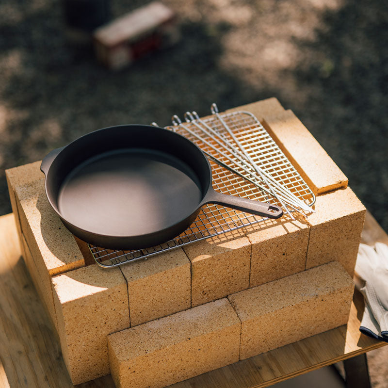 Field Cast Iron Skillet resting on grill grates atop the firebrick DIY Konro outdoors