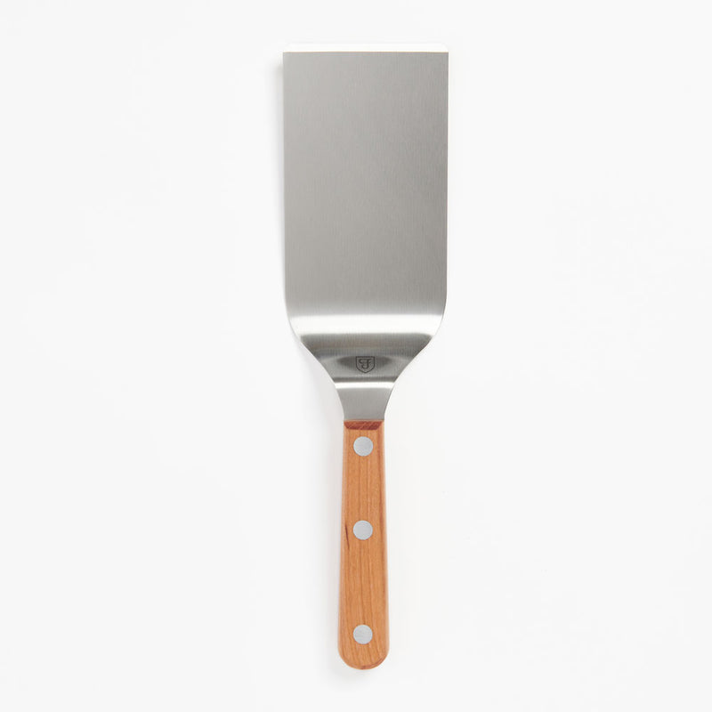 Field Griddle Turner with wide stainless steel blade and riveted wood handle on a white background