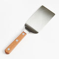 Angled view of the Field Griddle Turner with wide stainless blade and riveted cherry wood handle thumbnail