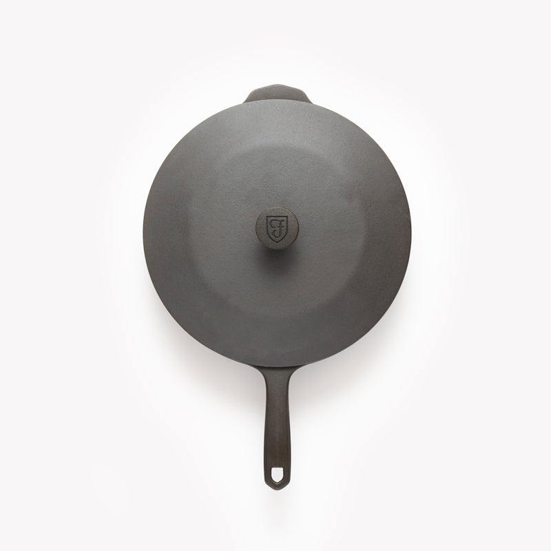 Overhead view of the No.10 Cast Iron Skillet Lid covering a Field Skillet, handle extending below