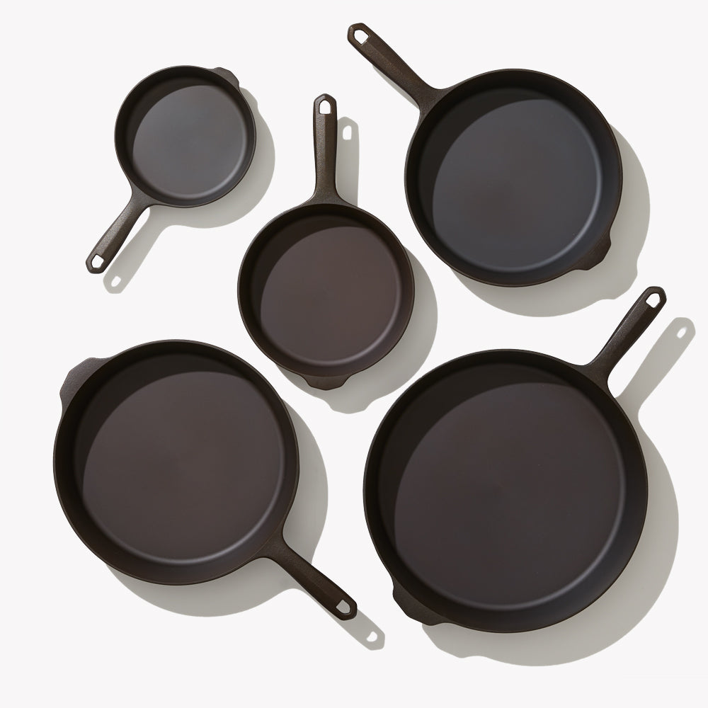 Overhead view of the 5-Piece Field Cast Iron Cookware Set, five skillet sizes arranged face up