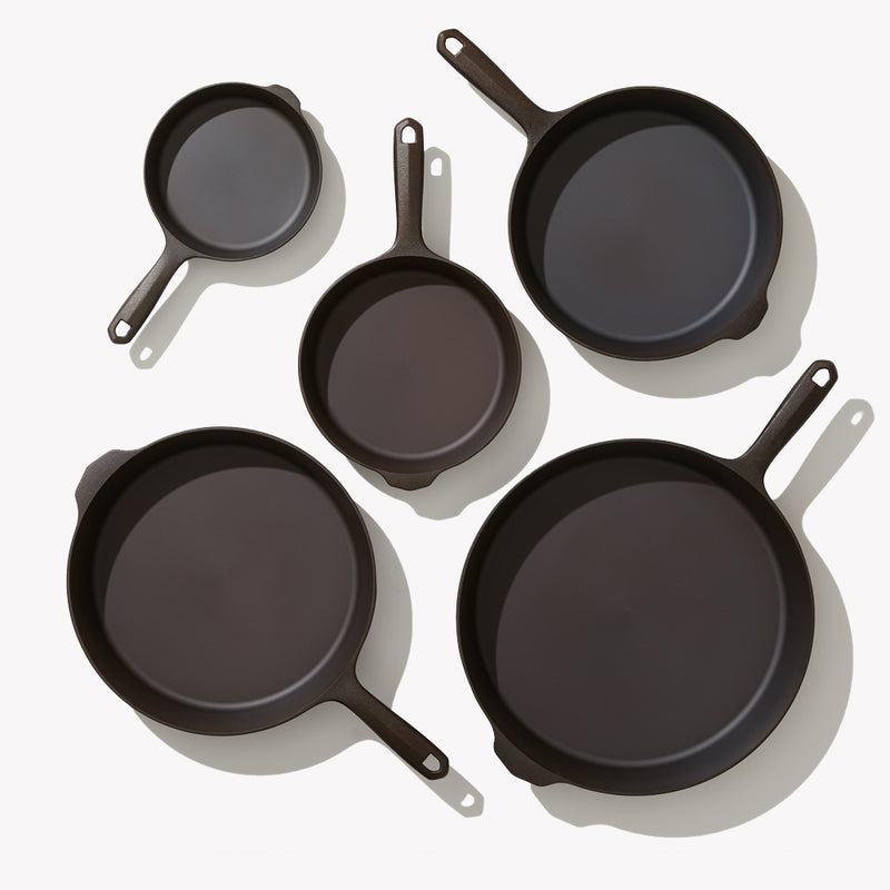 Overhead view of the 5-Piece Field Cast Iron Cookware Set, five skillet sizes arranged face up