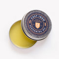 Open tin of Field Company Cast Iron Seasoning Oil with the lid tilted to show the balm-like oil blend inside thumbnail