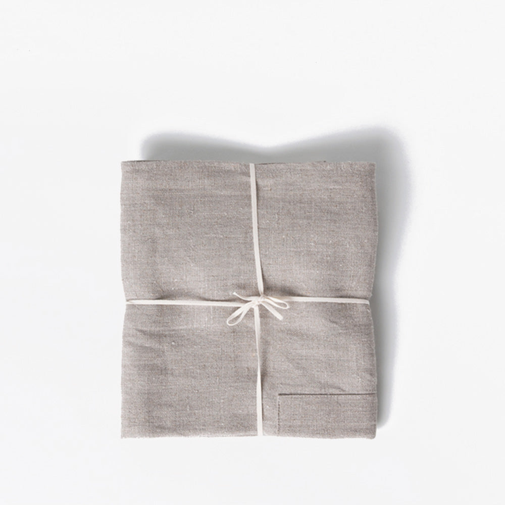 Field Company linen apron folded flat and tied with cotton string, studio shot